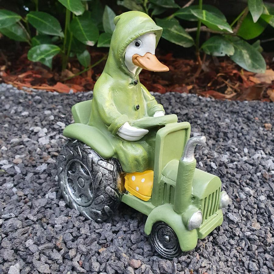 Ente mit Mantel auf Traktor als Gartenfigur