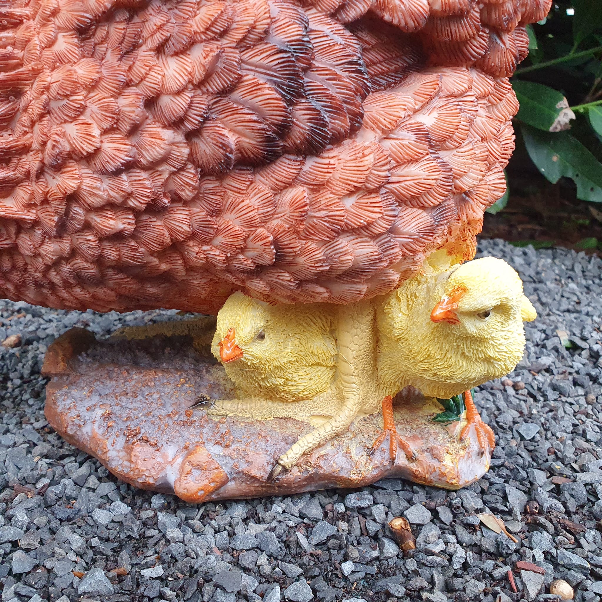 Pickende braune Hühner Gartenfigur mit gelben Küken nah Ansicht an die Küken