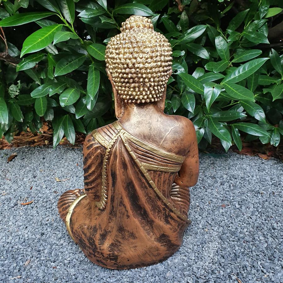 Gold sitzender Buddha mit beiden Händen oben Nahaufnahme von hinten