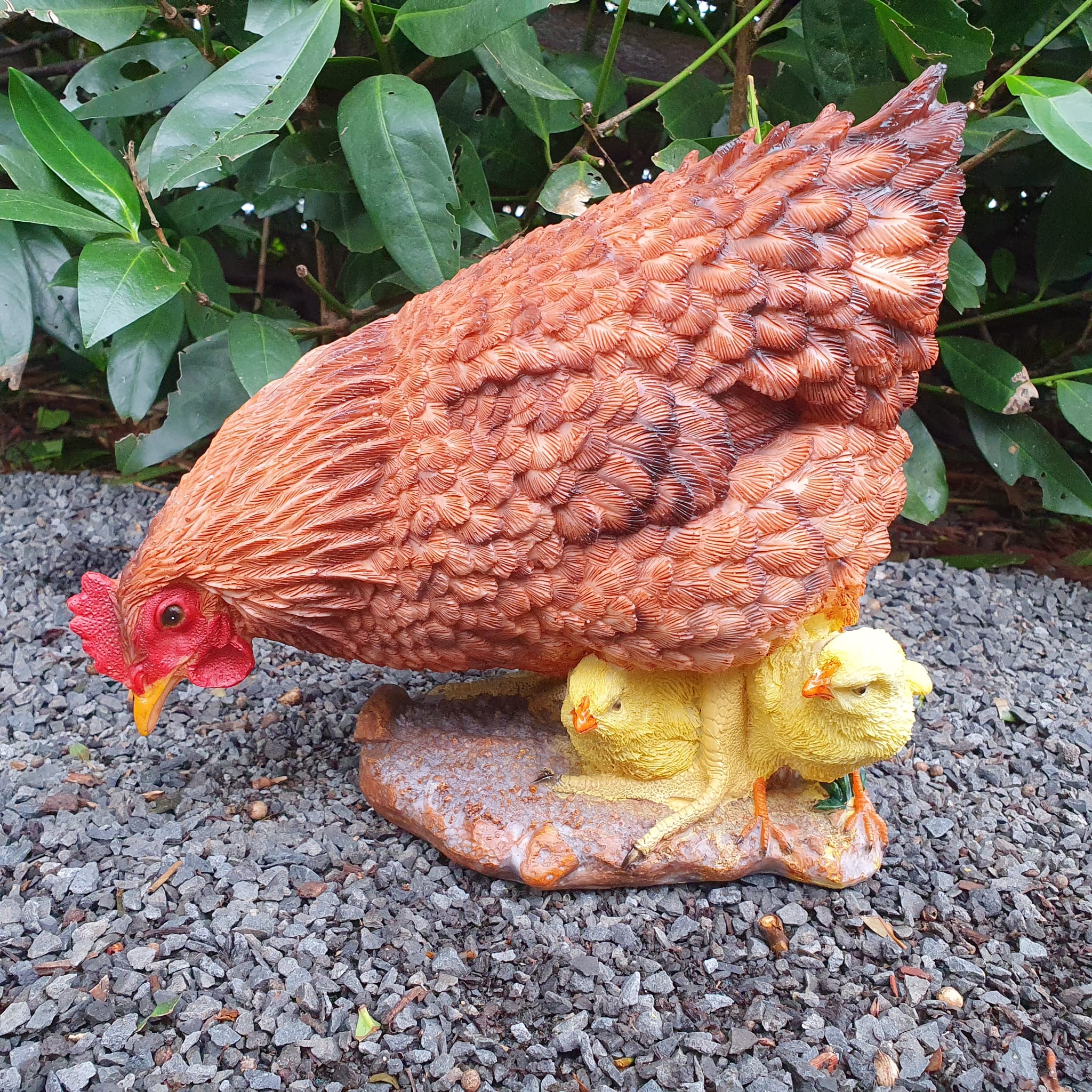 Pickende braune Hühner Gartenfigur mit gelben Küken