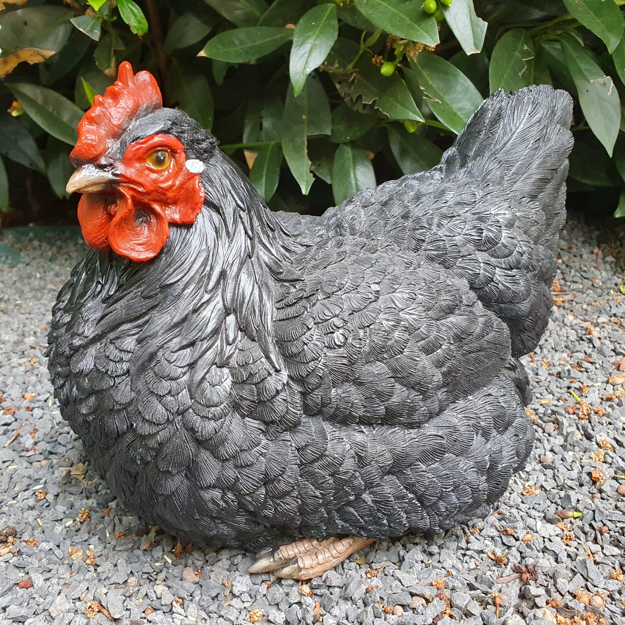 Schwarze sitzende Hühner Gartenfigur