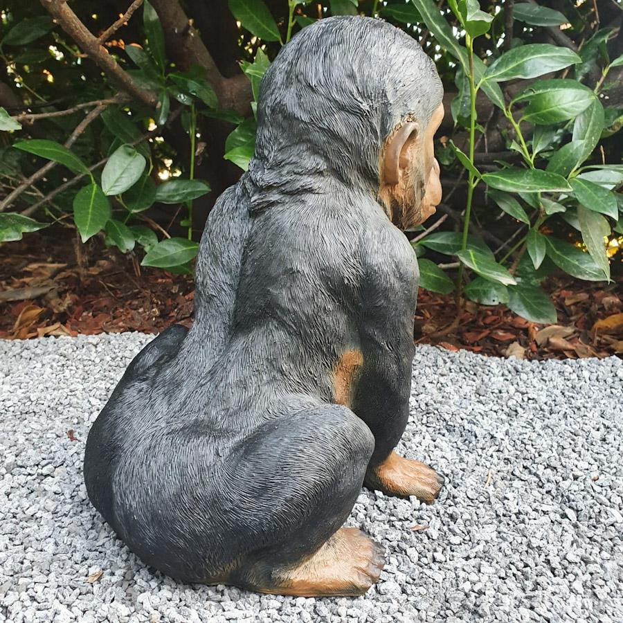 Baby Schimpanse als Gartenfigur von hinten