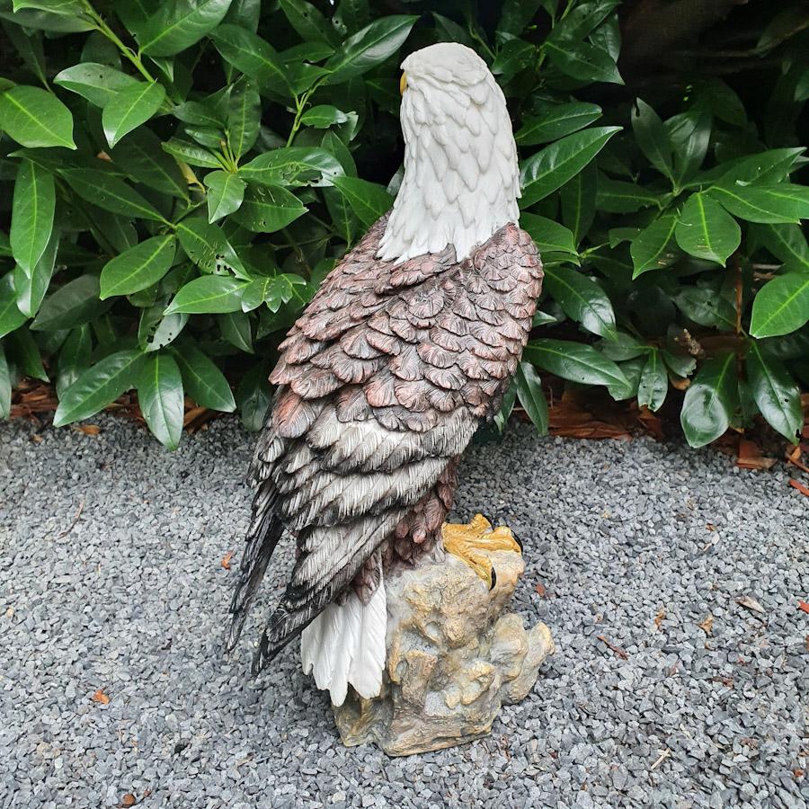 Adler auf Ast mit Weißem Kopf als Gartenfigur von hinten