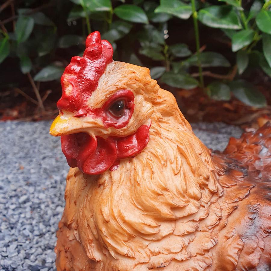Sitzende braune Hühner Figur nah Ansicht ans Gesicht