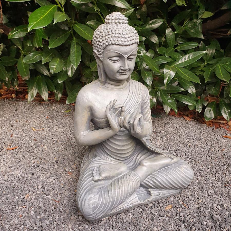 Grauer sitzender Buddha mit beiden Händen oben von hinten