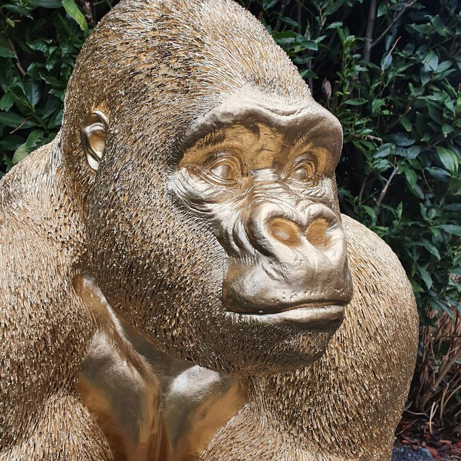 Großer Goldener Gorilla auf der Lauer als Gartenfigur Nahaufnahme 