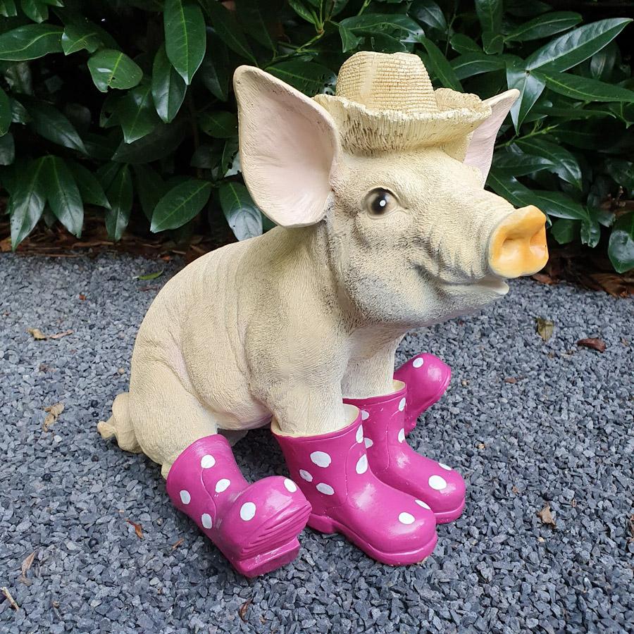  Sitzendes Schwein mit Hut und lila Stiefeln als Gartenfigur