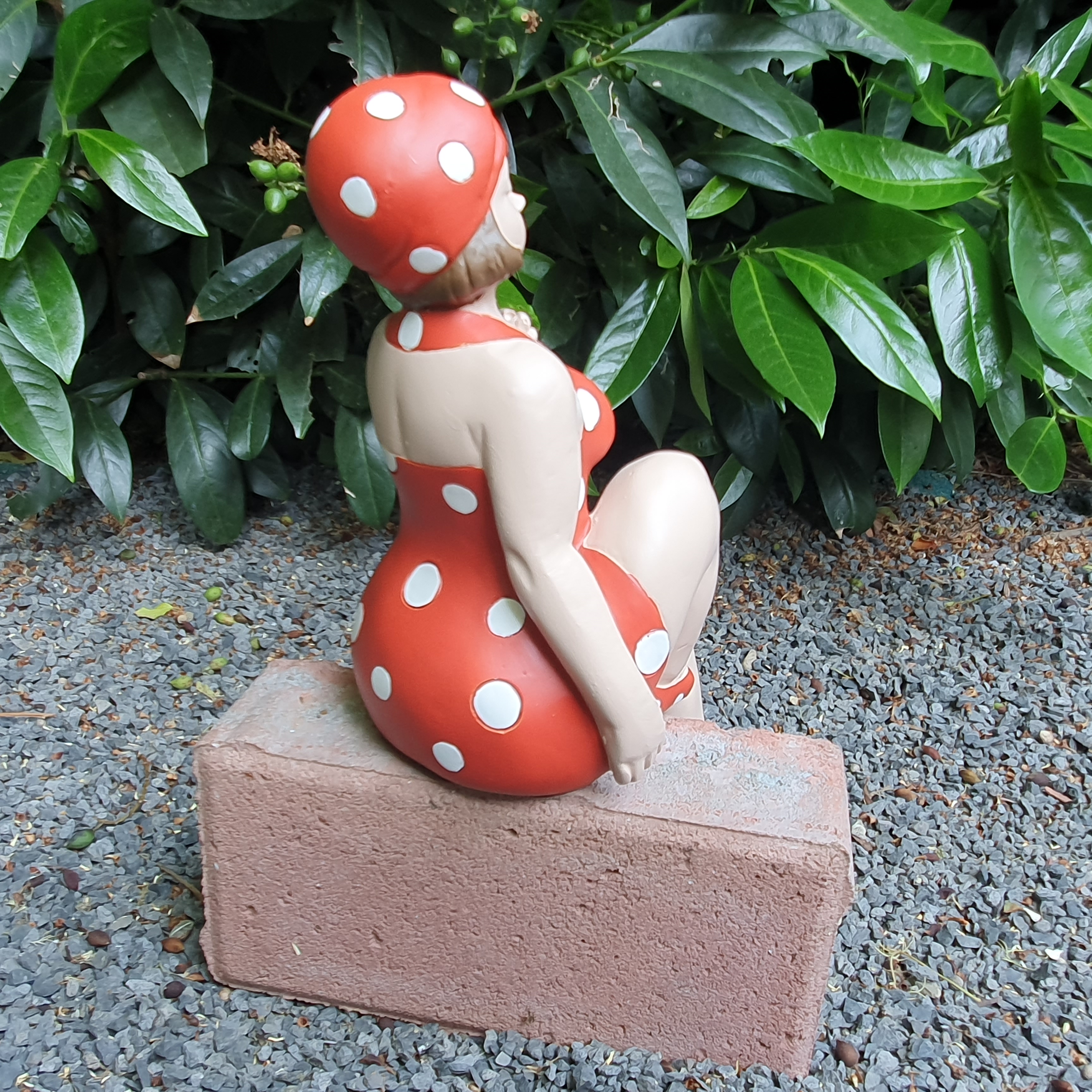 Badenixe im roten Badeanzug Kantensitzer als Gartenfigur von hinten