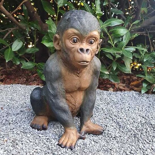 Gartenfigur Gorilla Baby Figur sitzt und strengt die Zunge 32 cm