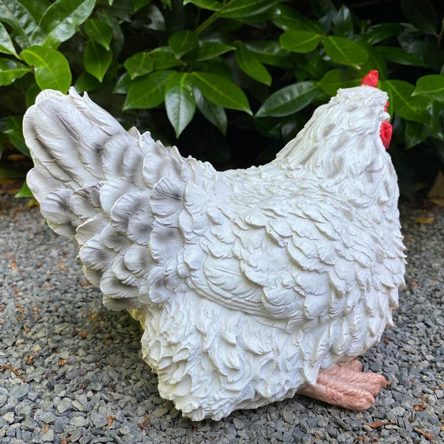 Weiße sitzende Hühner Gartenfigur von hinten