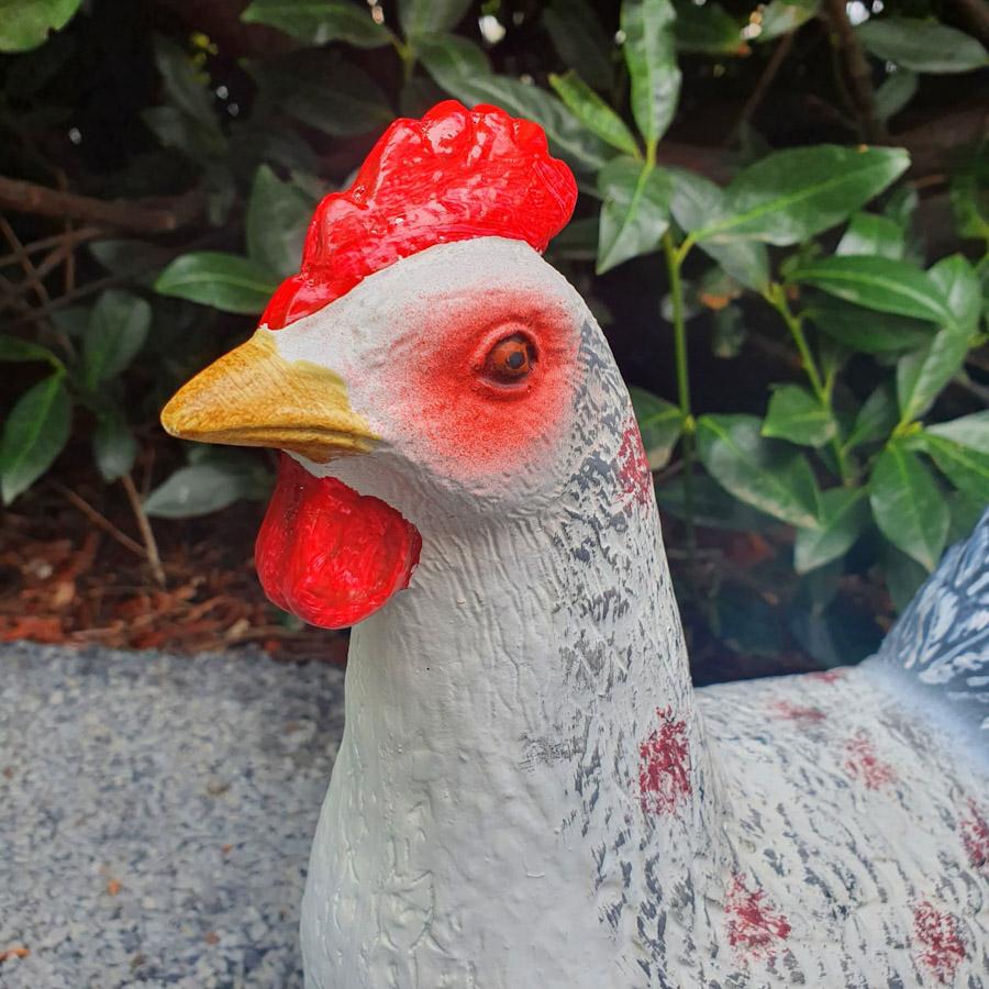 Stehende Hühner Figur weiß mit schwarzen Schwanzfedern nah Ansicht Kopf