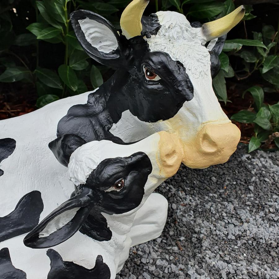  Liegende schwarzgeflekte Kuh mit Kalb als Gartenfigur Nahaufnahme Kopf