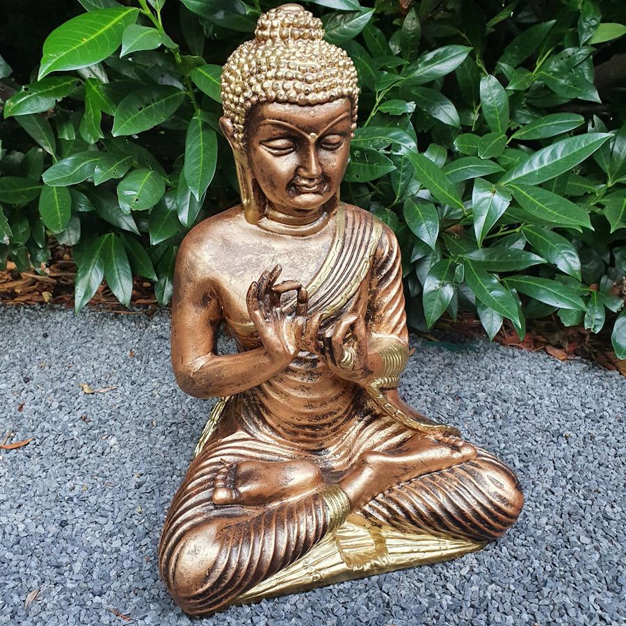 Gold sitzender Buddha mit beiden Händen oben Nahaufnahme